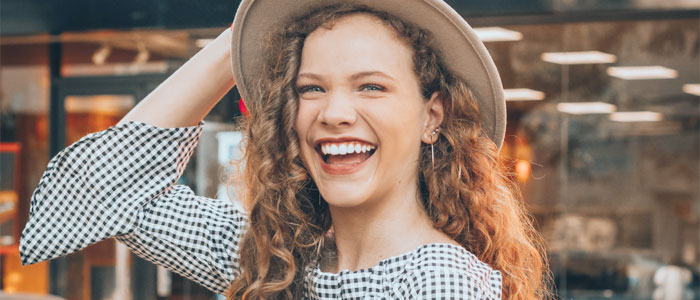 Curly haired woman with hat smiling west michigan dentists