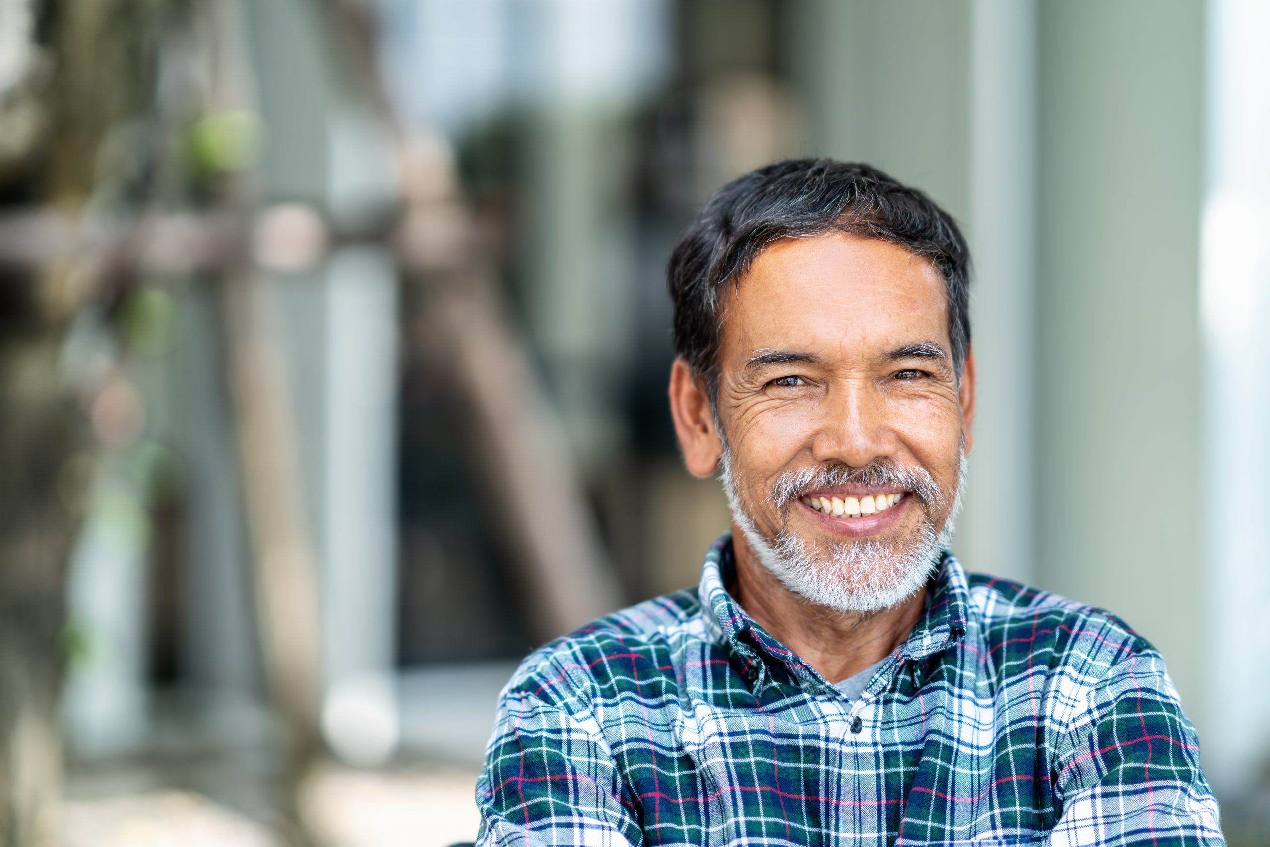 older man smiling in plaid shirt